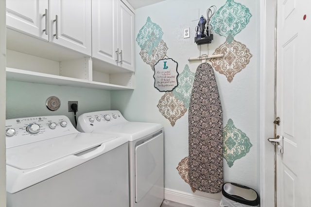 washroom with cabinets and washing machine and dryer