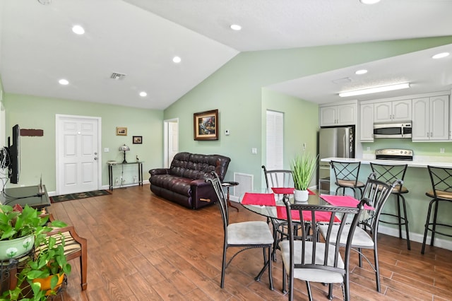 dining space with lofted ceiling and light wood-type flooring