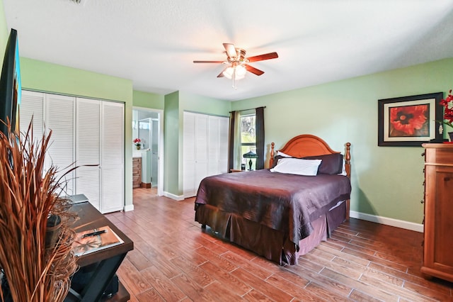 bedroom featuring ceiling fan, wood-type flooring, and multiple closets