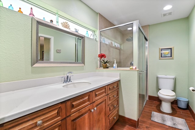 bathroom with toilet, walk in shower, and vanity