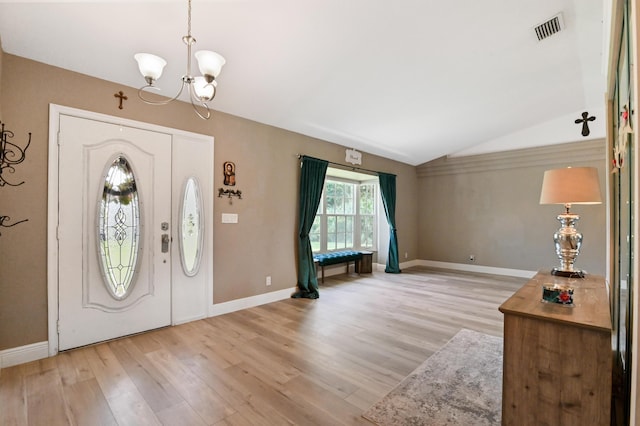 entryway with vaulted ceiling, a notable chandelier, and hardwood / wood-style floors