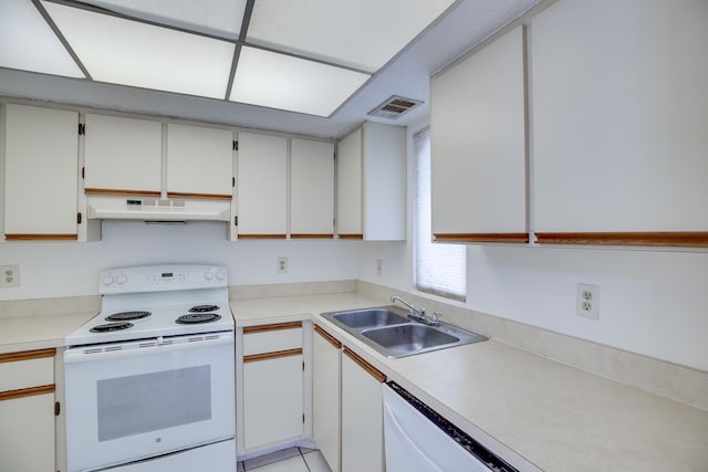 kitchen featuring sink, white appliances, and white cabinetry