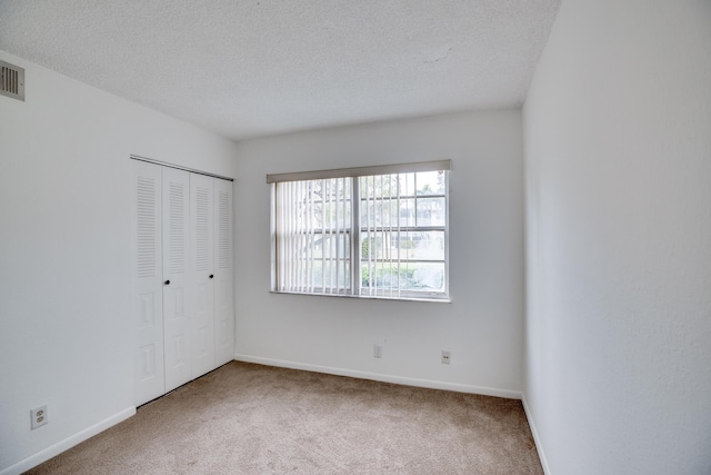 empty room featuring a textured ceiling and carpet floors