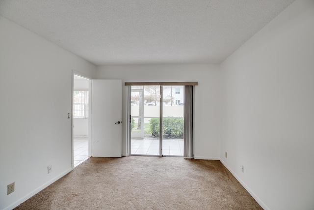 carpeted empty room with a textured ceiling