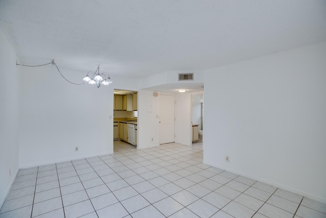 empty room featuring light tile patterned flooring and an inviting chandelier