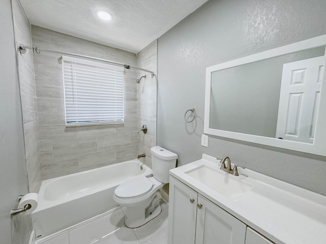 full bathroom featuring toilet, vanity, tile patterned floors, tiled shower / bath combo, and a textured ceiling