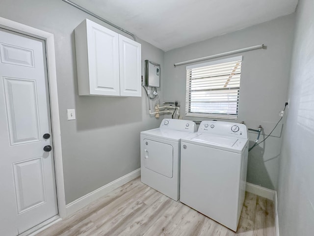 washroom featuring washer and dryer, cabinets, and light hardwood / wood-style floors