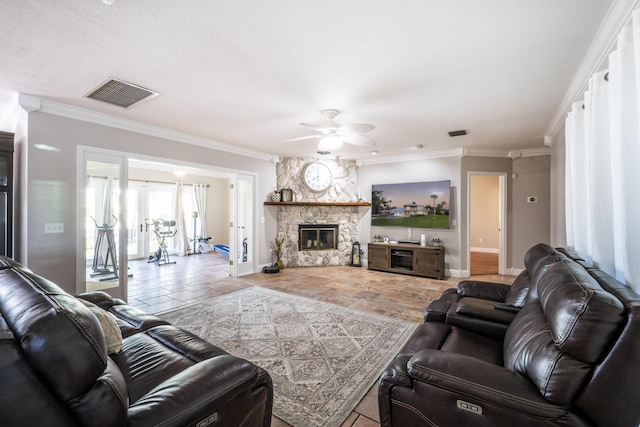 living room featuring ceiling fan, ornamental molding, and a stone fireplace