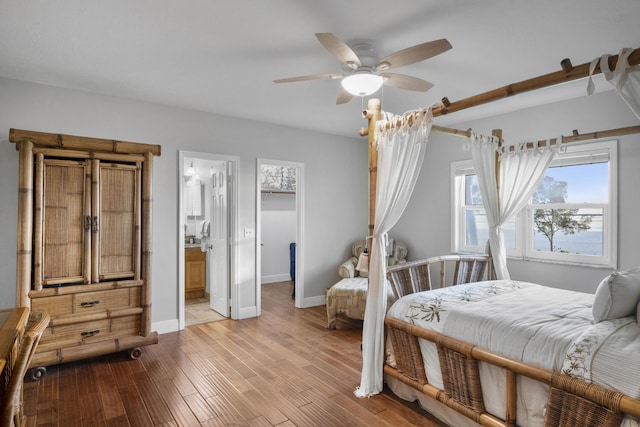 bedroom with ceiling fan, light hardwood / wood-style floors, and ensuite bath