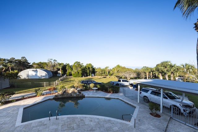 view of pool with a carport and a yard