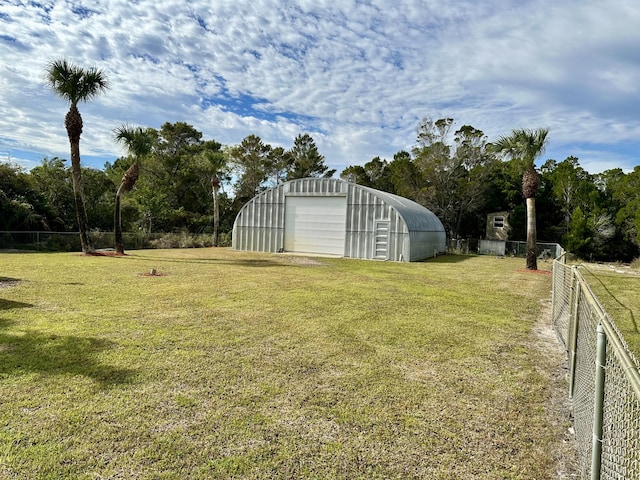 view of yard featuring a garage and an outbuilding