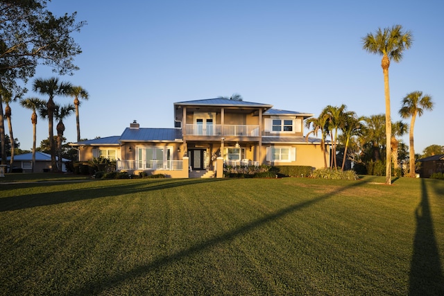 view of front of house with a front yard and a balcony