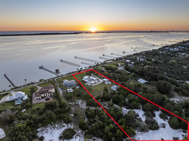 aerial view at dusk featuring a water view