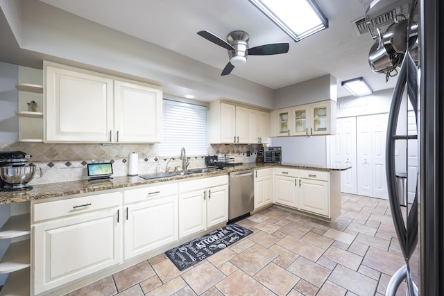 kitchen featuring dishwasher, black refrigerator, dark stone counters, sink, and ceiling fan