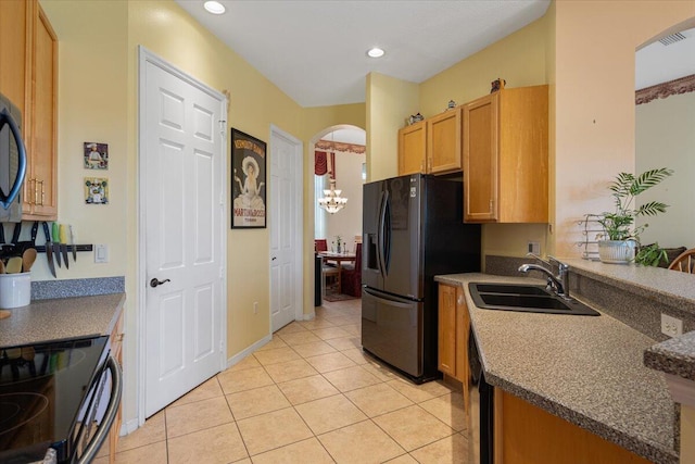 kitchen with sink, light tile patterned floors, black appliances, and an inviting chandelier