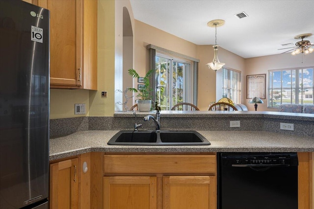 kitchen featuring ceiling fan, sink, stainless steel refrigerator, and black dishwasher