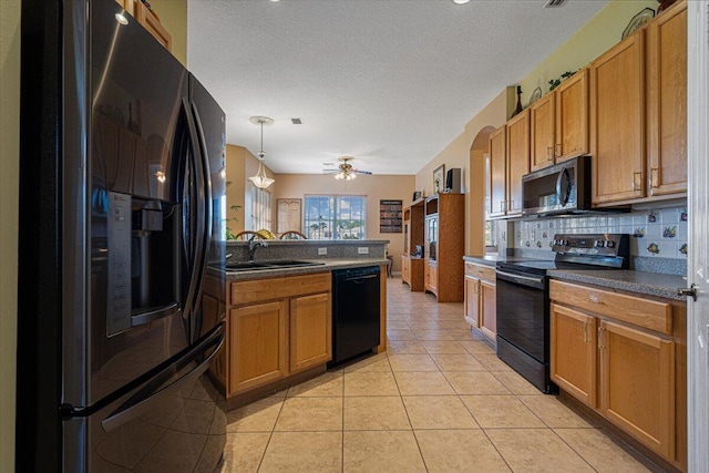 kitchen featuring black appliances, decorative light fixtures, sink, backsplash, and ceiling fan