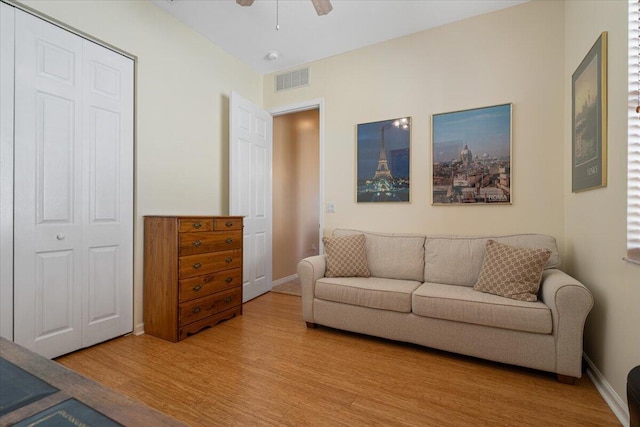 living room with light wood-type flooring and ceiling fan