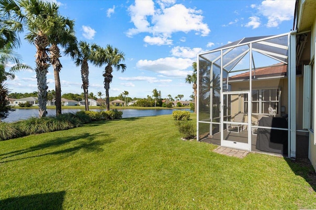 view of yard featuring glass enclosure and a water view