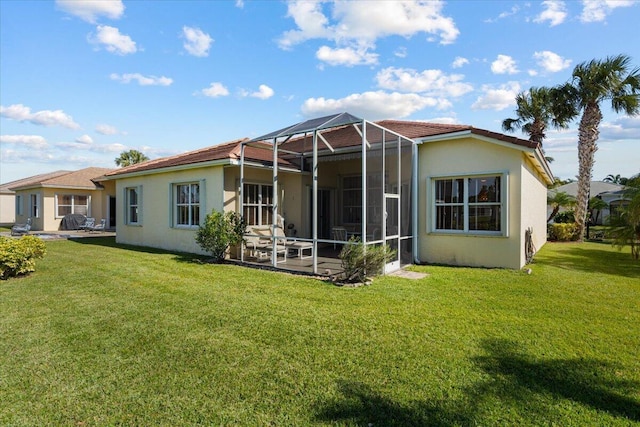 back of house with glass enclosure, a yard, and a patio