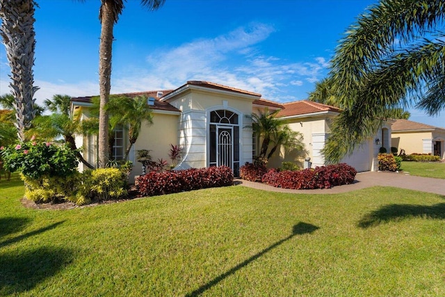 mediterranean / spanish-style house featuring a garage and a front yard