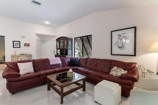 living room with vaulted ceiling and light tile patterned floors