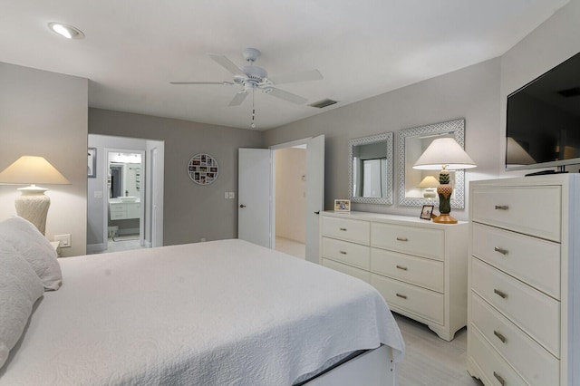 bedroom with ensuite bath, ceiling fan, and light hardwood / wood-style flooring