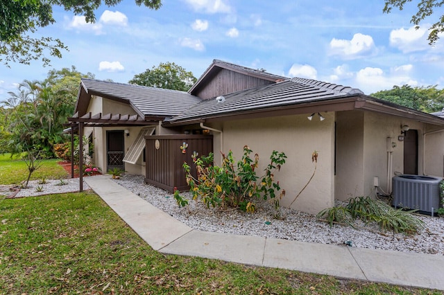 view of front of home with central air condition unit and a front lawn