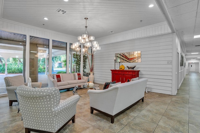 living room featuring ornamental molding, a notable chandelier, and wooden walls