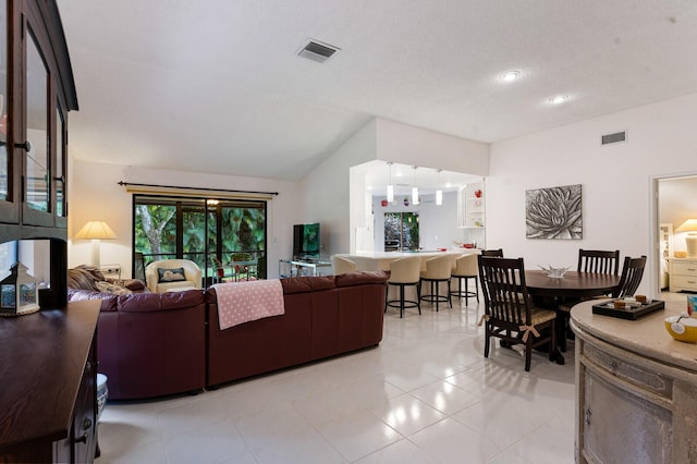 tiled living room featuring a textured ceiling and lofted ceiling