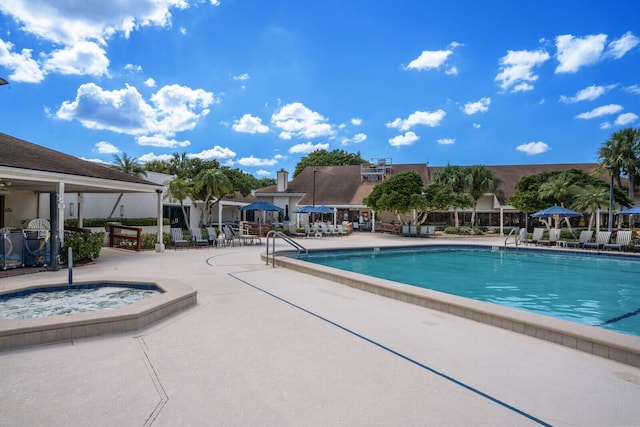 view of swimming pool featuring a community hot tub and a patio area