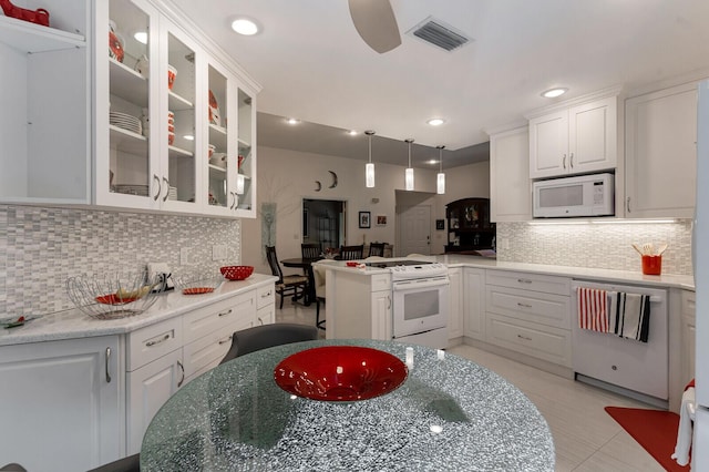 kitchen featuring white appliances, kitchen peninsula, pendant lighting, decorative backsplash, and white cabinetry