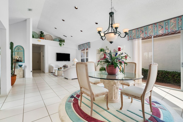 dining room with light tile patterned flooring, lofted ceiling, a textured ceiling, and an inviting chandelier