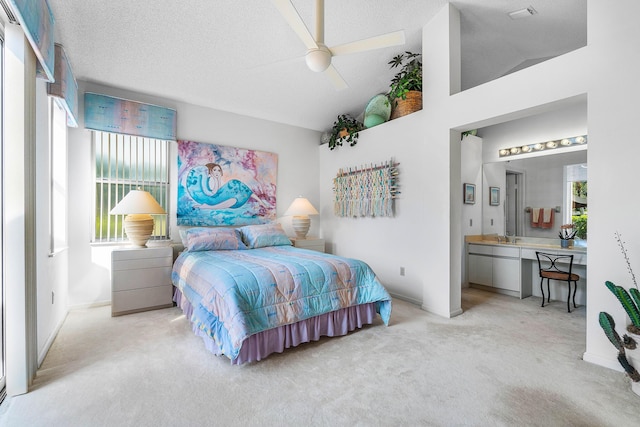 bedroom featuring lofted ceiling, ensuite bath, ceiling fan, a textured ceiling, and light carpet