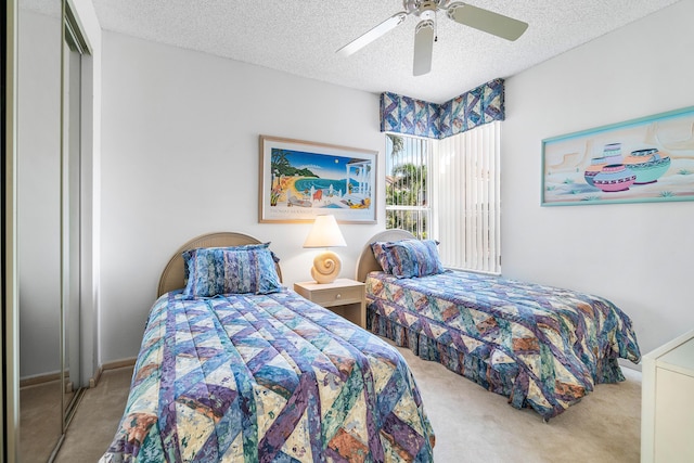 bedroom featuring ceiling fan, light colored carpet, and a textured ceiling