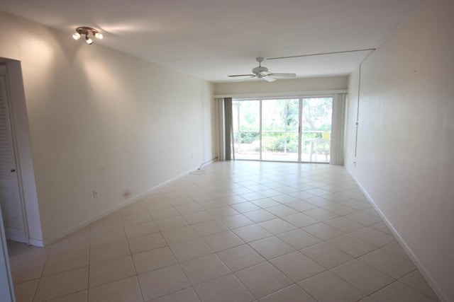 tiled empty room featuring ceiling fan