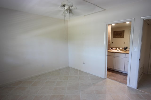 tiled spare room featuring ceiling fan and sink