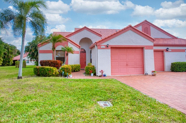 view of front of house with stucco siding, decorative driveway, a front lawn, and an attached garage