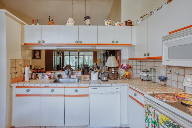 kitchen with tasteful backsplash, white appliances, white cabinetry, and a sink