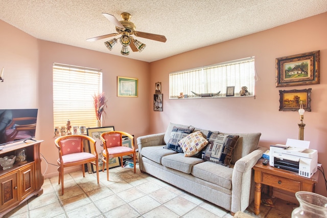 living room with a ceiling fan and a textured ceiling