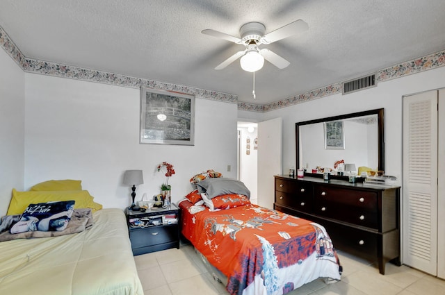 bedroom featuring light tile patterned floors, a textured ceiling, and ceiling fan