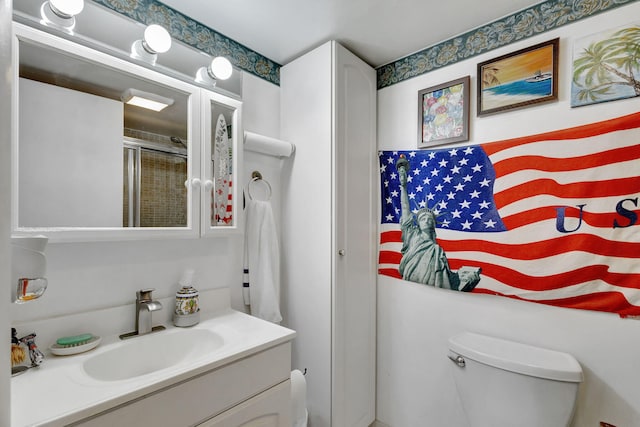 bathroom with walk in shower, vanity, and toilet