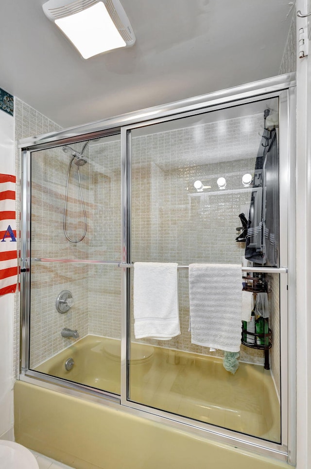 bathroom with shower / bath combination with glass door