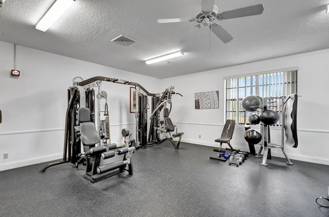 workout room featuring ceiling fan and a textured ceiling