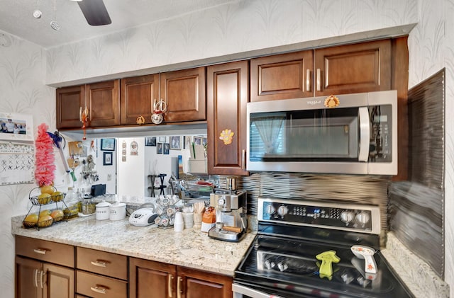 kitchen with electric stove, ceiling fan, and light stone countertops