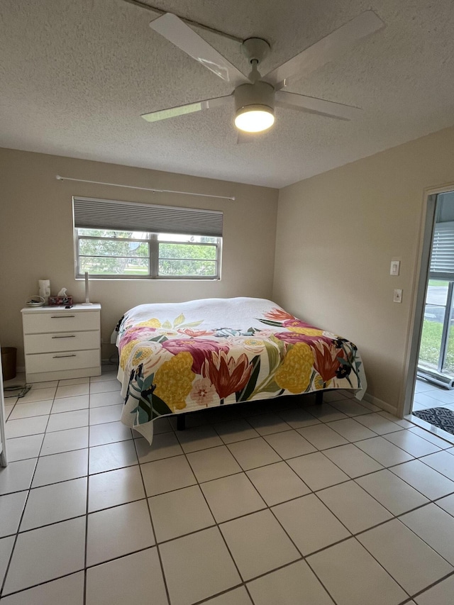 tiled bedroom featuring access to exterior, ceiling fan, and a textured ceiling