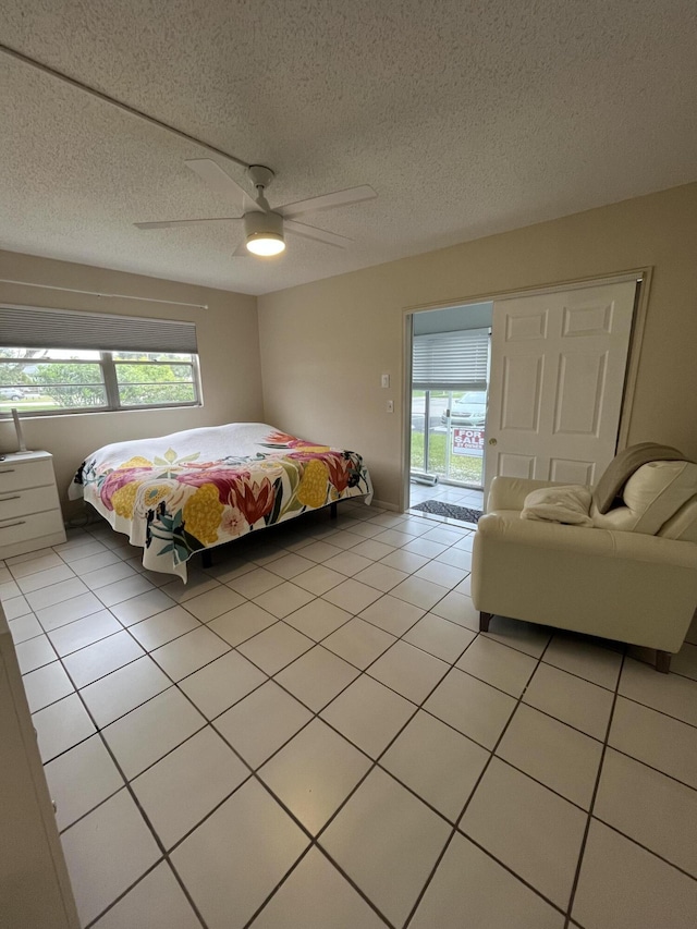 bedroom with ceiling fan, access to outside, multiple windows, and a textured ceiling