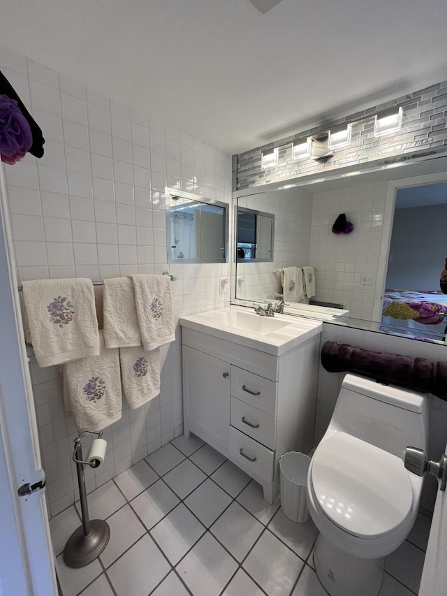 bathroom with toilet, tile patterned flooring, tile walls, backsplash, and vanity