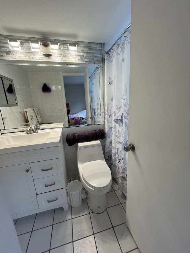 bathroom featuring tile walls, toilet, walk in shower, tile patterned floors, and vanity