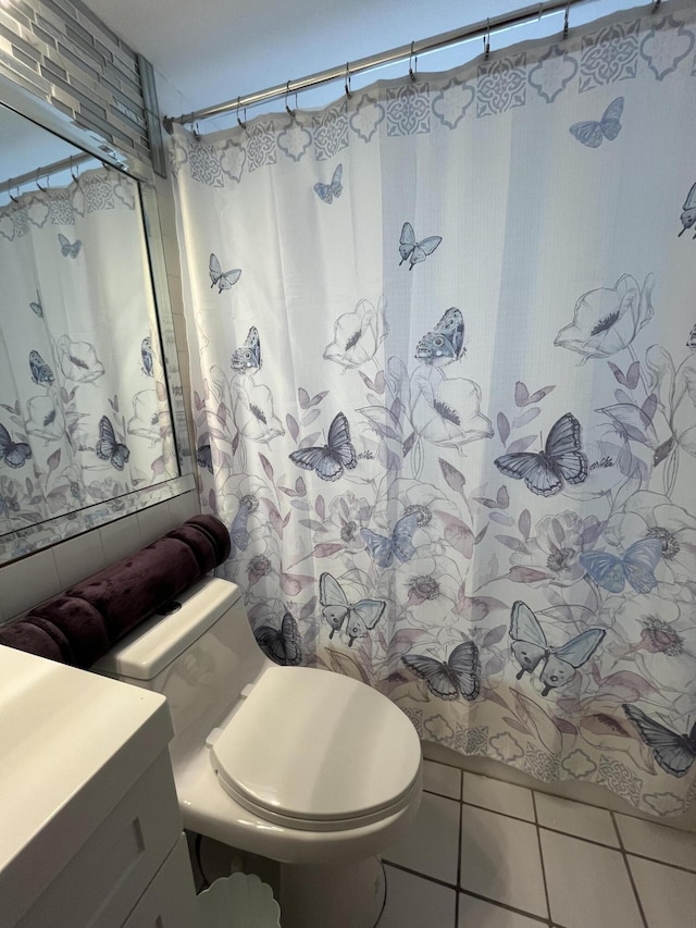 bathroom with toilet, tile patterned floors, and vanity